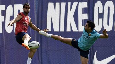 Barcelona’s defender Martin Montoya, left, and Barcelona’s midfielder Xavi Hernandez play with a rugby ball during a training session at the Sports Center FC Barcelona Joan Gamper in Sant Joan Despi, near Barcelona on April 15, 2014 on the eve of their Spanish Copa del Rey final football match against Real Madrid. AFP PHOTO/ LLUIS GENE