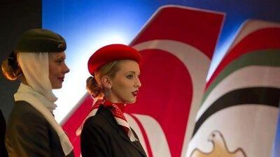 Air hostesses from Etihad Airways, left, and Air Berlin stand on the podium during a press conference in Berlin announcing the share sale. AFP