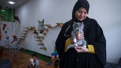 A woman plays with a cat at Meow Cafe. AFP