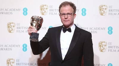 Writer Tom McCarthy with his award for Best Screenplay for the film Spotlight poses for photographers backstage. Joel Ryan / Invision / AP
