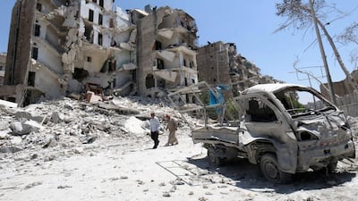 Syrian men walk amidst the rubble and debris in the Qadi Askar district of the northern Syrian city of Aleppo on July 5, 2015. Two alliances of Syrian rebels battled to advance in government-held western Aleppo, seizing an army barrack in one district but losing ground in others, in some of the fiercest fighting in the city since the conflict began. Zein Al Rifai/AFP Photo
