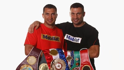 Wladimir Klitschko, left, and his brother Vitali pose with their championship belts in 2012. Getty Images