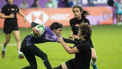 An Al Maha player is tackled by an Al Arabi player.