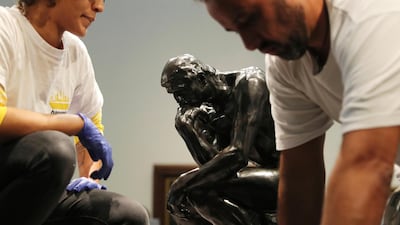Staff members prepare to move Rodin's 'The Thinker' bronze statue during installation at the Louvre Museum in Abu Dhabi. Kamran Jebreili / AP photo