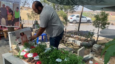 Narin Guran's father, Arif Guran, stands beside his daughter's grave in south-eastern Turkey's Diyarbakir province. Lizzie Porter / The National