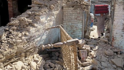 A man removes his belongings from a house damaged by massive earthquake in Mingora, the main town of Swat valley, Pakistan. Naveed Ali / AP Photo