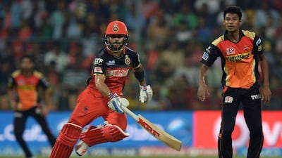 Royal Challengers Bangalore batsman Virat Kohli (C) makes a run while Sunrisers Hyderabad bowler Mustafizur Rehman (R) looks on during the 2016 Indian Premier League(IPL) Twenty20 cricket match between Royal Challengers Bangalore and Sunrisers Hyderabad at The M. Chinnaswamy Stadium in Bangalore on April 12, 2016. AFP / MANJUNATH KIRAN
