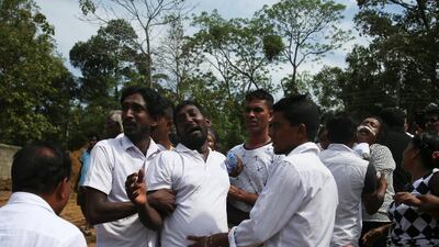 People react during a mass burial in Negombo. Reuters