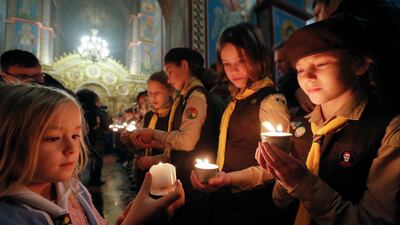 Members of the Plast National Scout Organisation of Ukraine share the Flame of Bethlehem during a ceremony to hand it over to the Metropolitan Epiphanius of Kyiv and All of Ukraine at St Mikhailovsky Cathedral in Kyiv last week. EPA