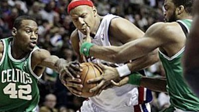The Pistons' Charlie Villanueva, centre, gets hit in the face by the Celtics' Sheldon Williams, right.