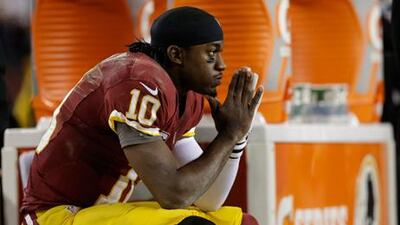Washington Redskins quarterback Robert Griffin III sits on the bench after his knee injury against Seattle.