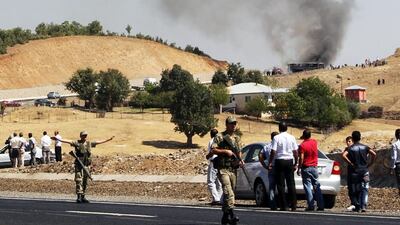 Turkish soldiers stand guard as smokes rises from a bus that was attacked by members of the PKK on September 18, 2012, in Bingol. AFP
