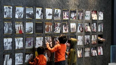 Children looking at old photos displayed at the exhibition.