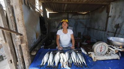 Margarita Perez poses in her fish stand in Gosen City. Perez is a single mother who supports her two children by selling fresh fish. Mariana Bazo / Reuters