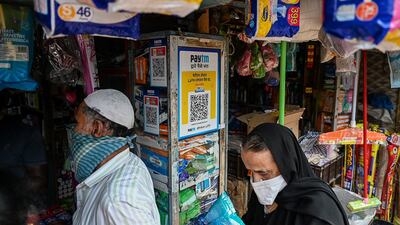 Customers outside a shop in Mumbai displaying QR codes for Paytm. The company's IPO last year was India's biggest. AFP