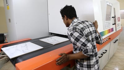A digital printer marks ceramic tiles at the RAK Ceramics factory. Pawan Singh / The National