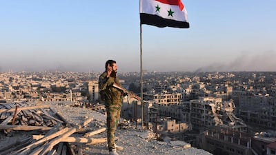 A Syrian pro-government fighter stands on top of a building overlooking Aleppo in the city's eastern Bustan Al Basha neighbourhood on November 28, 2016. George Ourfalian/AFP