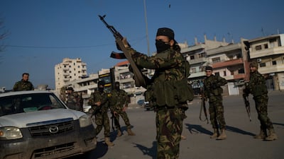 A member of the HTS security forces takes part in an operation to detain men suspected of being part of militias or Assad loyalists in Homs, Syria. AP