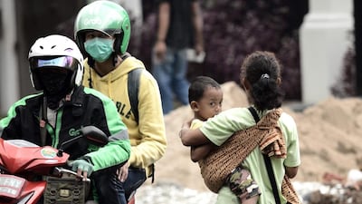 A jockey is seen holding her child as she looks to be hired as a passenger in exchange for a small fee in the streets of Jakarta. Authorities are cracking down on drivers who try to exploit Jakarta’s carpooling laws by hiring a few extra passengers. Goh Chai Hin / AFP