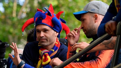 Andres Iniesta waves at fans during Barcelona's open-top bus celebrations. Lluis Gene / AFP