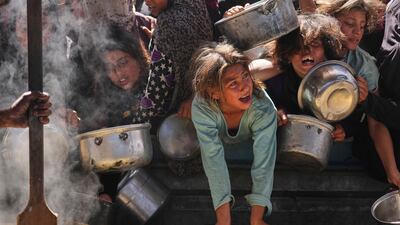 Palestinians struggle to get donated food at a community kitchen in Khan Younis, Gaza Strip. AP Photo