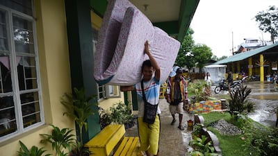 A resident carries a matress inside a classroom being used as evacuation centre inTuguegarao, Cagayan province. Ted Aljibe / AFP