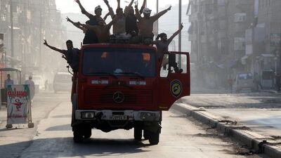 Syrian civil defence volunteers, known as the White Helmets, celebrate in an Aleppo street on August 6 after rebels said they had broken a three-week government siege on the city. Thaer Mohammed / AFP