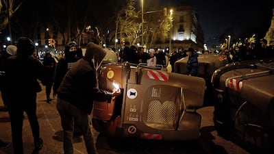 A protester sets fire to trash containers during clashes with Catalan regional police forces. AFP