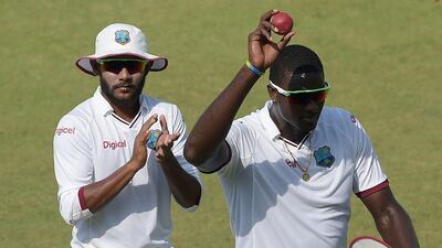 West Indies’ cricket captain Jason Holder holds the ball after taking five wickets in the match against Pakistan as he walks back to pavilion with teammate Devendra Bishoo on the fourth day of the third and final Test at the Sharjah Cricket Stadium on November 2, 2016. Aamir Qureshi / AFP
