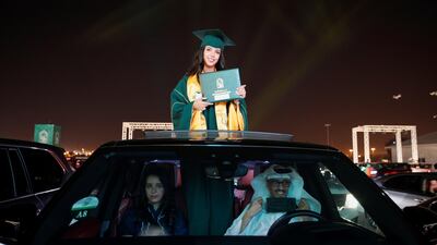 Having collected her certificate from the podium and returned to her family car, a pupil poses through the sunroof. Reuters