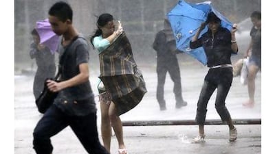 People brave strong winds and rain on a street as a typhoon hit Haikou in south China's Hainan province yesterday. AP Photo