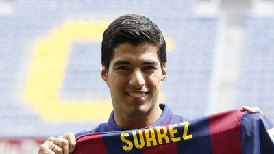 Luis Suarez poses with his Barcelona jersey during a presentation at the Camp Nou on Tuesday. Gustau Nacarino / Reuters / August 19, 2014