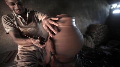 An Egyptian potter shapes a clay pot at one of the traditional pottery workshops, in Old Cairo, Egypt.