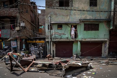 A Muslim man watches from his house after a shop was demolished in the area, following communal violence during a Hindu religious procession, in April. AP