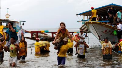 epa06401088 (FILE) - Filipino port workers carry disembarking passengers at a port in the coastal town of Infanta, Quezon province, Philippines, 13 November 2016. (reissued 21 December 2017). According to news reports, a ferry carrying 251 passengers capsized off the Philippines coast in stormy weather. Huge waves slammed into the boat causing it to sink in the seas off Dinahican village in nearby Infanta town. EPA/FRANCIS R. MALASIG FILE