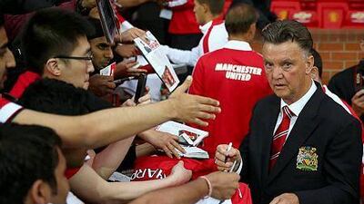 Manchester United manager Louis van Gaal signs autographs as he makes his home debut during the Pre Season Friendly match between Manchester United and Valencia at Old Trafford on August 12, 2014 in Manchester, England. (Photo by Clive Brunskill/Getty Images)