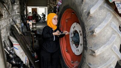 Mechanic Amal Zanaty, 50, repairs the wheel of a tractor at a garage in Kafr El Sheikh, Egypt. Reuters