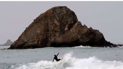 A surfer takes advantage of the large waves caused by the cyclone at Snoopy Island in Fujairah yesterday.