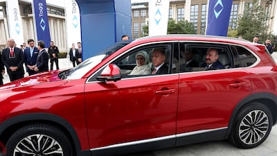 Turkey's Industry and Technology Minister Mustafa Varank, right, joins the couple for a spin