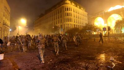 Smoke rises as Lebanese army soldiers walk during a protest against the newly formed government in Beirut. Reuters