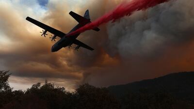 A Modular Airborne Fire Fighting Systems-equipped C-130 aircraft drops retardant ahead of the LNU Lightning Complex fire in Healdsburg, California. AFP