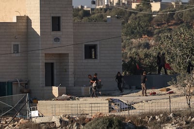 Israeli settlers stand near seized properties belonging to the Tobasi family in Jalud. EPA