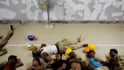 Labourers of Amana Contracting and Steel Buildings take a nap during the mandatory rest hours yesterday, the first day it was implemented in summer.