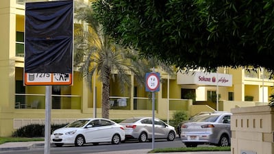 A partially covered paid parking board at The Greens. Tenants and owners living in the community have requested ther developer Emaar to exempt them from the new paid parking rules. Antonie Robertson / The National