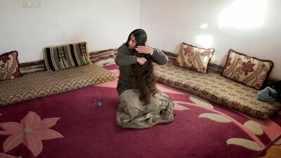 Haval Raperin, a member and leader of a group of Kurdistan Workers Party (PKK) fighters combs her hair at a base in Sinjar, Iraq.
