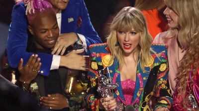 Taylor Swift accepts the Video of the Year award for 'You Need to Calm Down' at the MTV Video Music Awards. Jade Jolie can be seen in pink behind Swift. AP