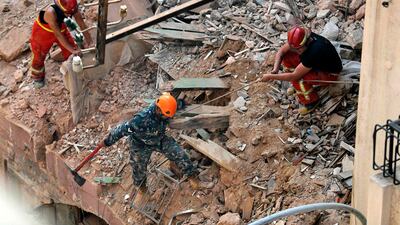 Rescue workers dig through the rubble of a badly damaged building in Lebanon's capital Beirut, in search of possible survivors from a mega-blast at the adjacent port one month ago, after scanners detected a pulse. Lebanese rescuers scoured rubble for a possible survivor in Beirut after the detection of a pulse drew crowds hopeful of a miracle one month on from a devastating explosion. AFP