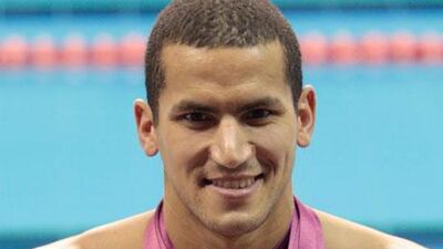 Oussama Mellouli, the Tunisian swimmer, poses with 15 gold medals after winning the best athlete in the Arab Games in Doha.