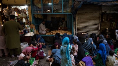 Afghan women and children wait at a bakery for bread donations in Kabul's Old City, Afghanistan, on September 16. AP