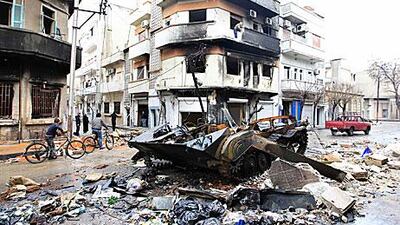 A damaged armoured vehicle belonging to the Syrian army is seen in a street in Homs. The Syrian government rejected the Arab League plan to extend their mission, called the proposal a “blatant interference” in its domestic affairs.